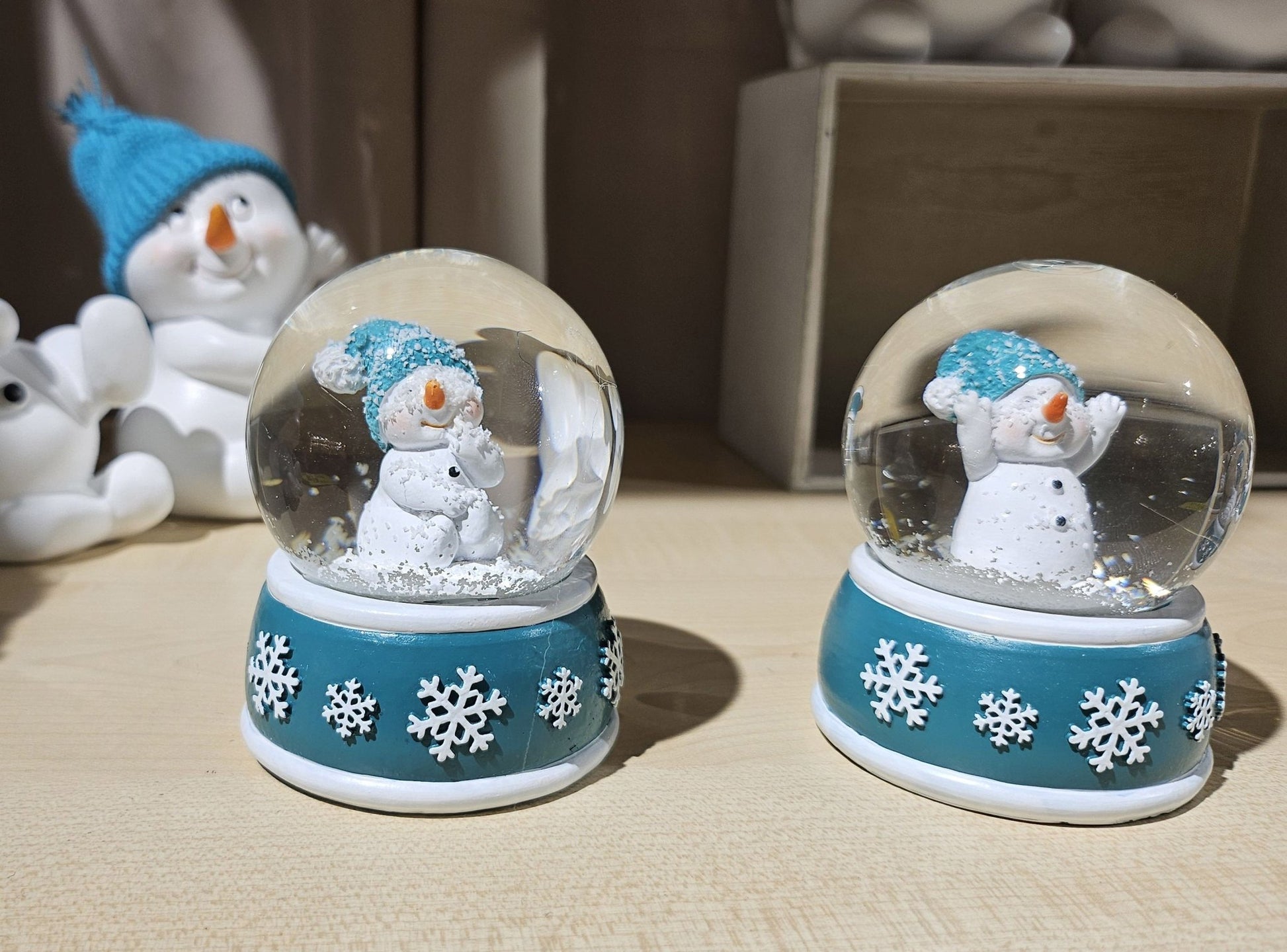 Süße Schneekugel Schneemann Hände hoch auf Sockel türkis weiße Schneeflocke B: 65mm - Schneekugelhaus